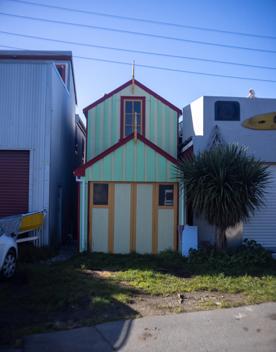 The Petone boat ramp, Hikoikoi,  with colourful boat sheds and boats in the morning sun.