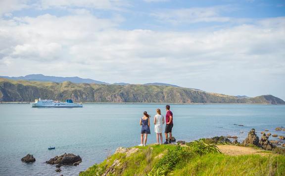 A group of people on the Eastern Walkway, looking at Wellington’s South Coast as the Interislander ferry sails by.
