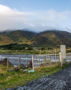 The screen location of Ōrongorongo Station, with many buildings, old and new, as well as views of the ocean and mountains.