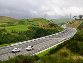 The 4 lane motorway of Transmission Gully, surrounded by green hills.