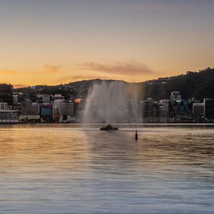 The Carter Memorial fountain spouts water at dusk with the Wellington skyline in the background.