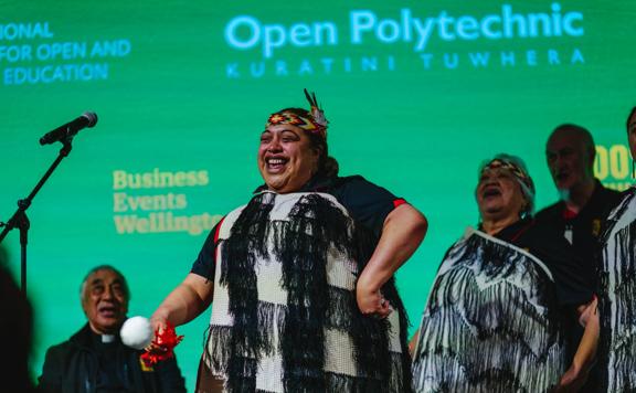 Person in traditional Maori dress performing on stage at ICDE World Conferenc