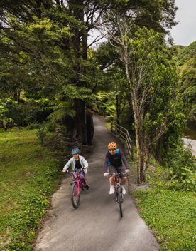 An adult and child cycle along the Hutt River Trail.