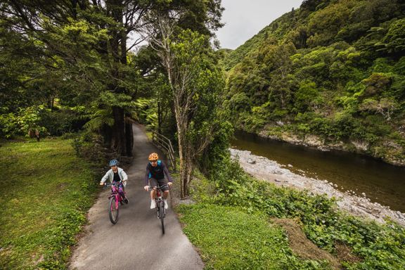 An adult and child cycle along the Hutt River Trail.