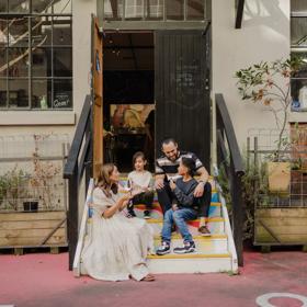 A family of four sits in the colourful steps leading to Wellington Chocolate Factory in Hannahs Laneway.