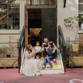 A family of four sits in the colourful steps leading to Wellington Chocolate Factory in Hannahs Laneway.