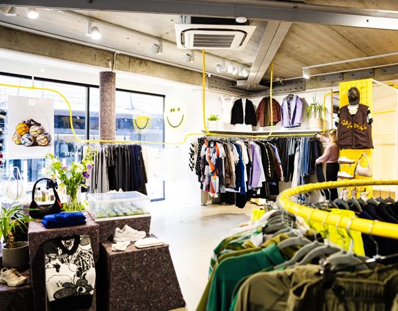 Interior of Good As Gold fashion store in Wellington showing clothing on display on painted yellow clothing racks.