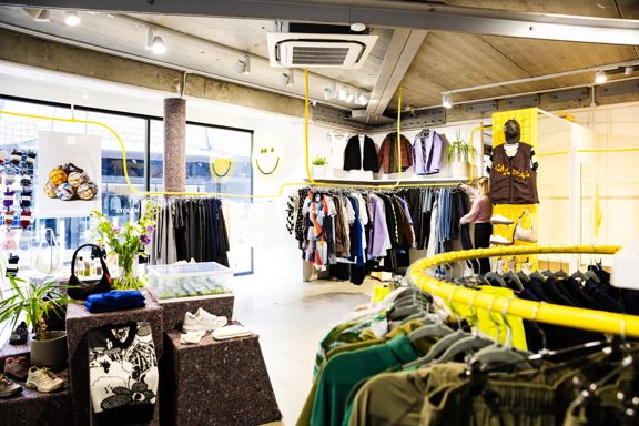 Interior of Good As Gold fashion store in Wellington showing clothing on display on painted yellow clothing racks.