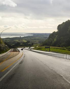 The 4 lane motorway of Transmission Gully, surrounded by green hills.