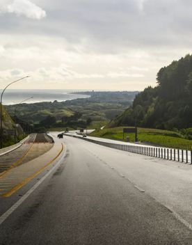 The 4 lane motorway of Transmission Gully, surrounded by green hills.