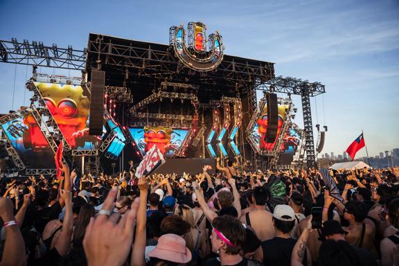 An outdoor stage at Ultra Worldwide Music Festival in Melbourne, Australia, with huge screens, speakers, and a packed cheering audience.
