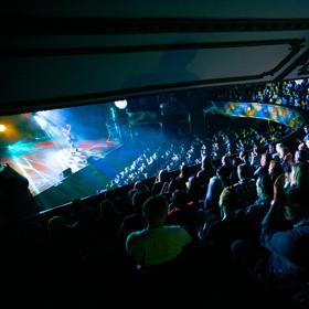 A comedian performs on stage to a packed audience at The Opera House in Wellington.