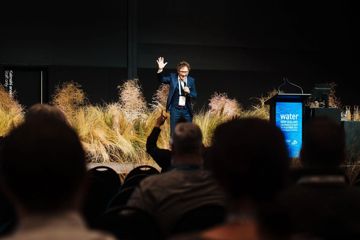 A presenter on a stage at the WaterNZ conference.