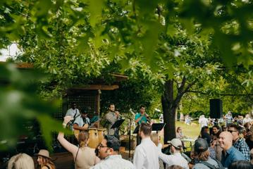 A small concert outdoors with a packed audience.