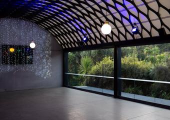 The Kamala function space at the zoo has a concrete floor and metal mesh detail ceiling. Glass doors line one side and twinkle lights hang at one end.