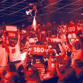 An excited audience cheering and holding red signs with the number "180" on them at the Professional Darts Corporation ANZ Premiere League competition.