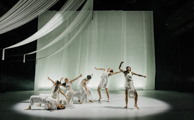 Six performers wearing white dance on stage at Ka Mua Ka Muri from Atamira Dance Company, part of Kia Mau Festival.