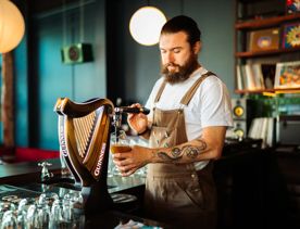 Bartender pouring a glass of Guinness from the tap.
