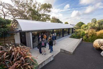 The exterior of the Kamala venue at Wellington Zoo has a curved white roof. Glass doors line one entire side, opening out onto a concrete patio and steps.