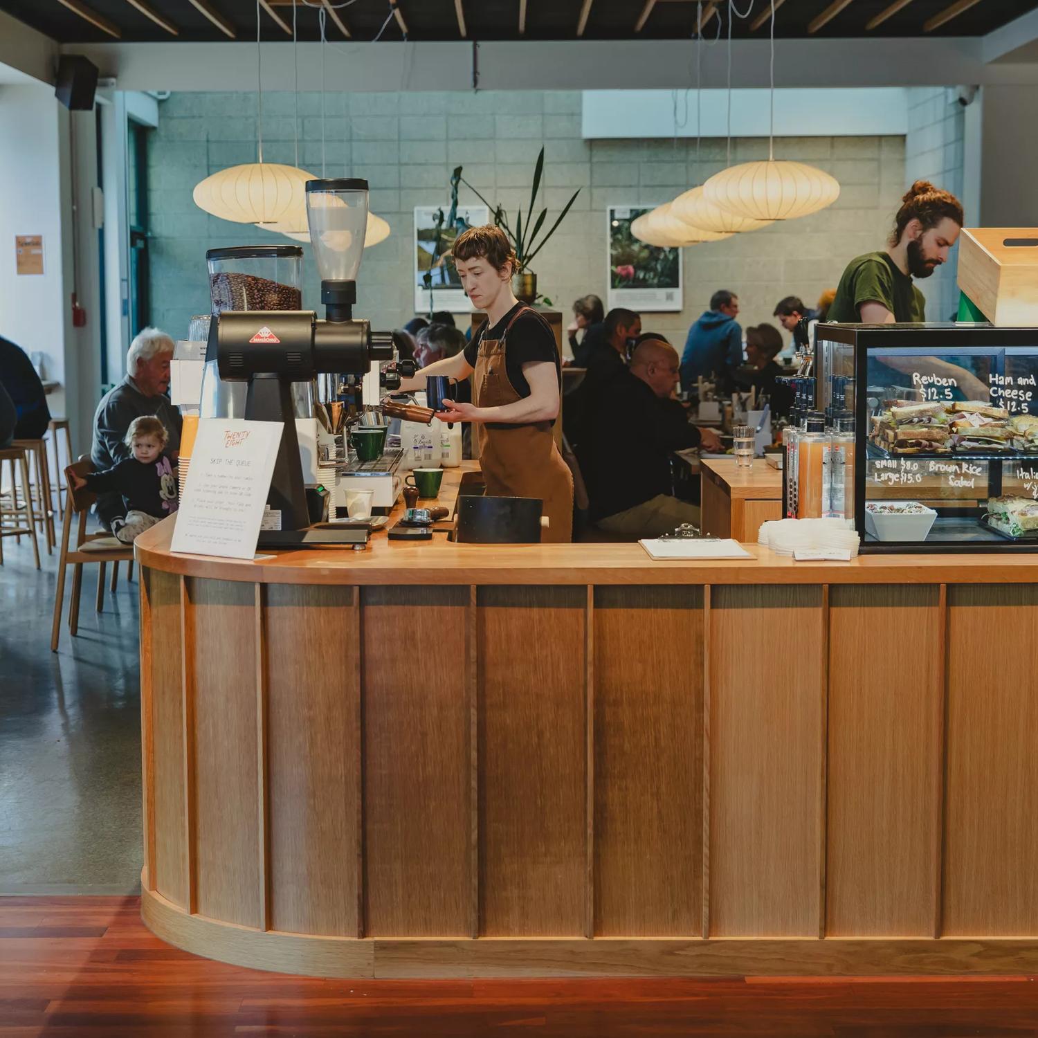 The front counter at Twenty Eight Cafe, located at 28 Cornwall Street in Lower Hutt, with two people working.