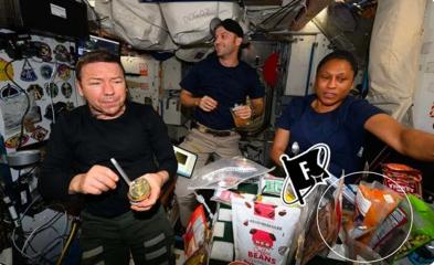 Three astronauts aboard the International Space Station eating food, with the Fix & Fogg peanut butter in a red circle.