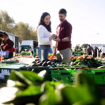 Two people shopping at an outdoor market.