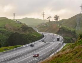 The 4 lane motorway of Transmission Gully, surrounded by green hills.