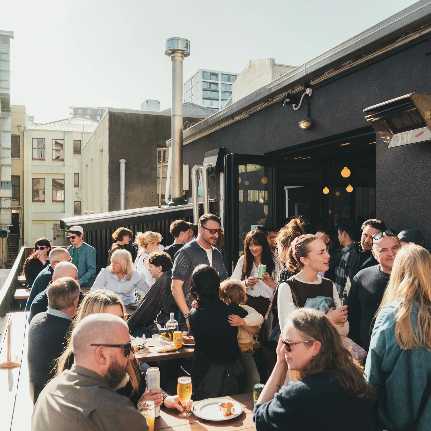 The sunny outdoor patio buzzes with patrons at Garage Project Leeds Street.