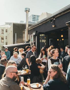 The sunny outdoor patio buzzes with patrons at Garage Project Leeds Street.