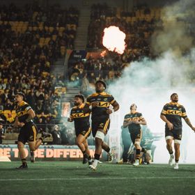 Members of the Hurricanes rugby team from Wellington running onto the pitch.