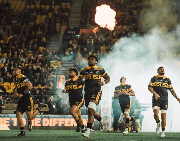 Members of the Hurricanes rugby team from Wellington running onto the pitch.