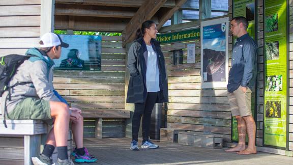 A fmaily talking to the tour guide at the visiotr information centre Kapiti Island.