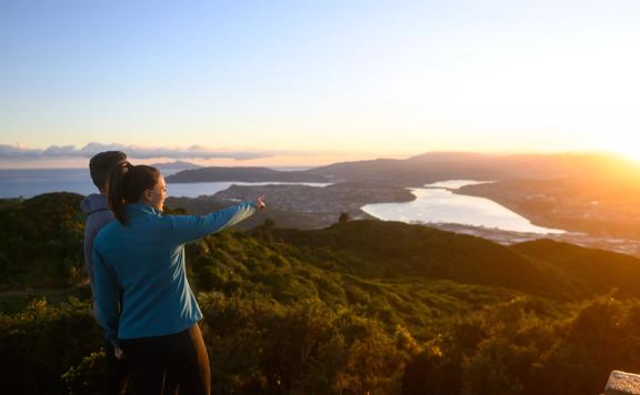 Two people look at the sunset from Rangituhi/Colonial Knob Walkway.