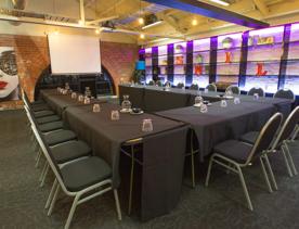 Chairs around square tables in a function room.