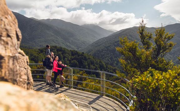 A family of four enjoy the view from Rocky Lookout on Mount Holdsworth in Tararua Forest Park.