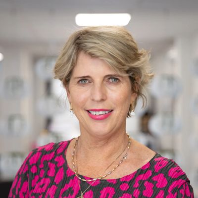 Portrait of Clare Menzies wearing a pink spotty blouse and blurred background.