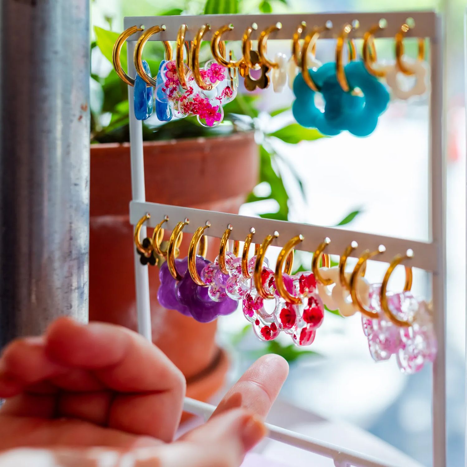 Colourful hoop earrings displayed on a jewellery stand at Preloved Charlies.