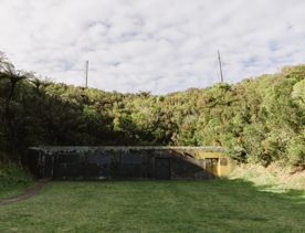 War Shelter No.1 is a concrete bunker, overgrown with moss, tucked into the base of a hill.