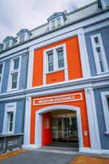 The entrance to the Wellington Museum, housed in an 1892 heritage building, is painted pale blue with a bright orange entrance.