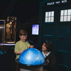 A child and mother play with a swirling orb at the Doctor Who exhibition.