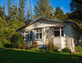 Camp Wainuiomata screen location. Has several buildings and is surrounded by forest and bush.