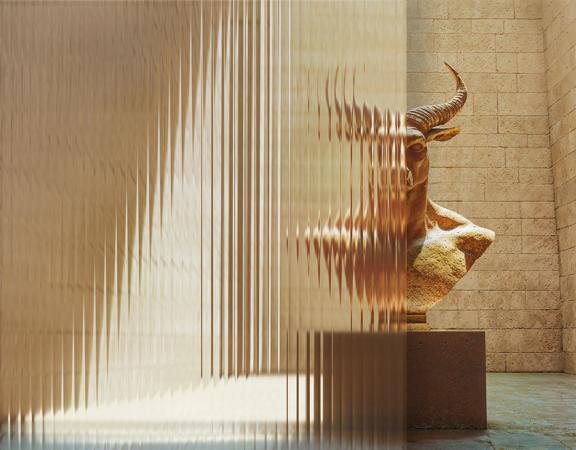 A minotaur bust behind fluted glass.