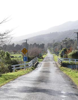 Mangaroa Valley Road screen location, a scenic rural setting with native forest, farmland, and a mountainous backdrop.