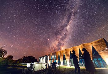 A couple sips wine at Urlar Gladstone winery under the crystal clear night sky in Wairarapa.