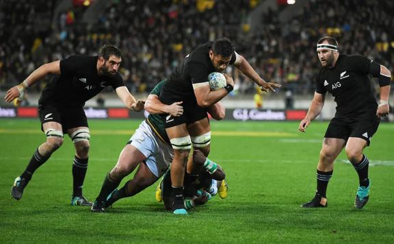 Four rugby players fighting for the ball during an All Blacks game. 