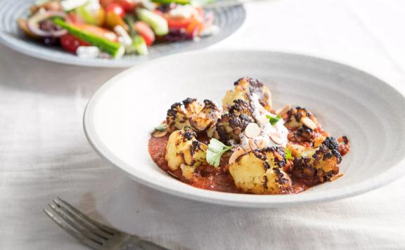 Close-up of a plate of cooked cauliflower and salad from Oikos Greek restaurant. 