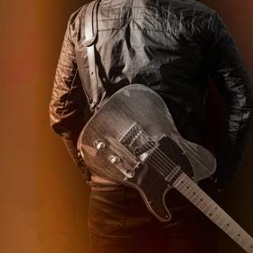 A person in a leather jacket with an electric guitar stepped to their back facing away on a brown-orange gradient background.