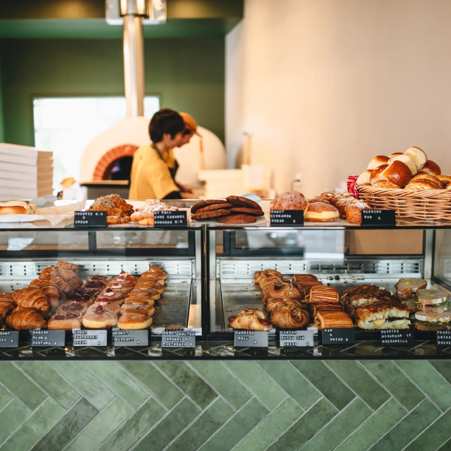 The front counter at a bakery with sandwiches, pastries and other baked goods on display.