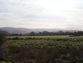 Mangaroa Valley Road screen location, a scenic rural setting with native forest, farmland, and a mountainous backdrop.