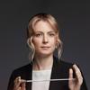 New Zealand-born conductor, Gemma New, holds a conductor's baton.